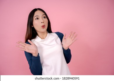 Young Asian woman showing an emotional surprise, standing with gasped on a pink background. She was shocked.