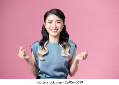 Young Asian woman showing mini heart sign isolated on pink background, Spreading love and happiness concept - Shutterstock ID 2240648699