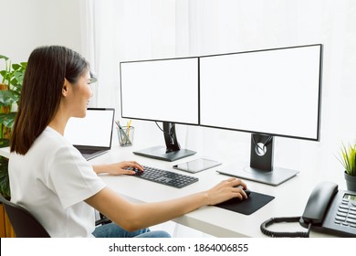 Young Asian Woman Sitting On Chair And Working At The Computer With Blank Screen In Home On The Day Light Shone In The Afternoon.