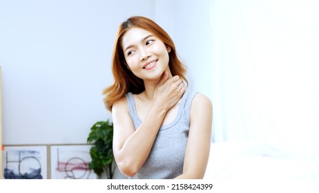 Young Asian woman sitting on bed to massage neck and shoulder, for soothing and relaxing in the morning. Concept of self massage. - Shutterstock ID 2158424399