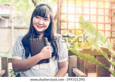 Young asian woman sitting at a table using tablet.