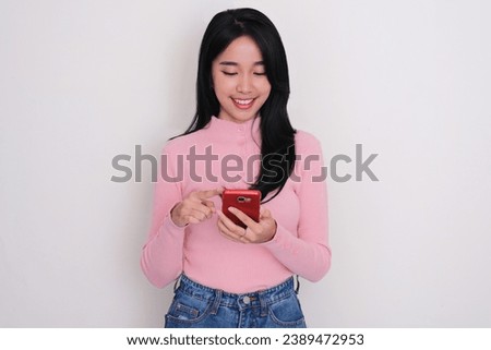 Young Asian woman smiling happy when looking to his mobile phone 