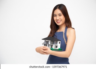 Young Asian woman smiling and hugging dream house sample model isolated over white background, Real estate and home insurance concept - Shutterstock ID 1597367971