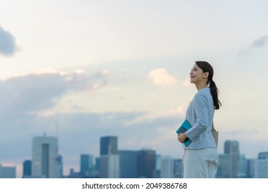 Young asian woman standing in front of the city. - Shutterstock ID 2049386768