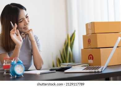 A Young Asian Woman Starting A Small E-commerce Business Is Working On A Laptop And Chatting With Customers Over The Internet.