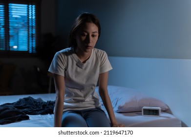 Young Asian Woman Suffer From Insomnia Can't Sleep At Night Awaken From Stress Mental Health Problem Or Migraine. Young People Health Care Psychiatry Concept. Woman Sitting On Bed Can't Sleep At Night