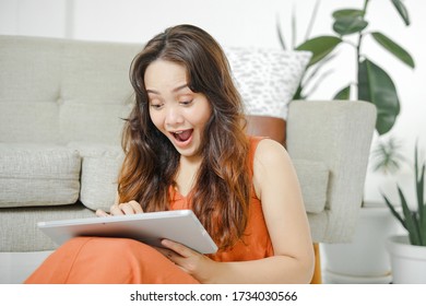 Young Asian Woman Was Surprised When She Saw Her Tablet Computer. Asian Women Are Surprised To See Discounts At Online Stores