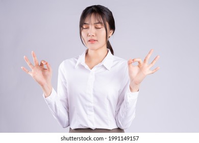 Young Asian Woman Taking Deep Breaths To Stay Calm
