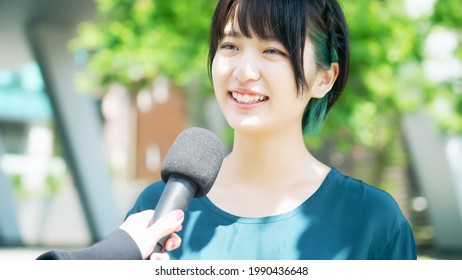 Young Asian Woman Taking Interview On The Street.