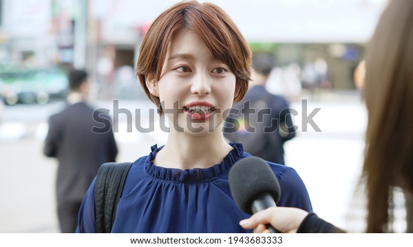 Young asian\
woman taking interview of TV\
program.