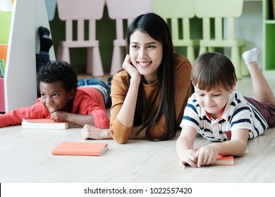 Young asian woman teacher and American, African boys in kindergarten classroom, preschool education concept