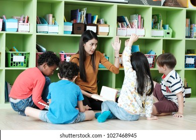 Young asian woman teacher teaching kids in kindergarten classroom, preschool education concept