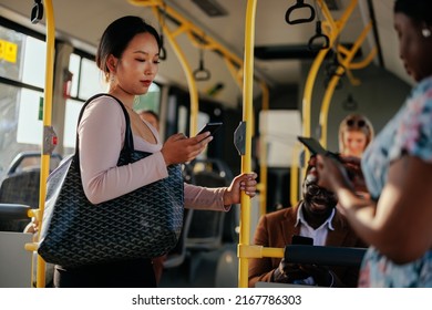 A young Asian woman is texting while riding in public transportation