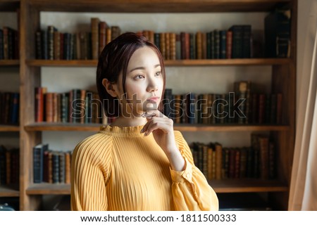 Young asian woman thinking in library.