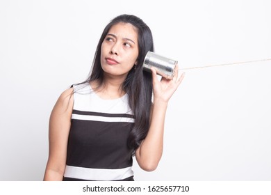 Young Asian woman with tin can phone on white background