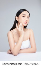 Young Asian woman touch and worry about her face. Acne, pimple, clear and clean, oily, dry skin concept. - Shutterstock ID 2152401021