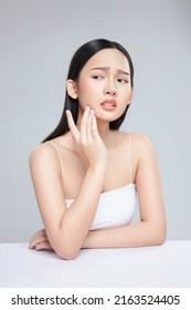 Young Asian woman touch and worry about her face. Acne, pimple, clear and clean, oily, dry skin concept. - Shutterstock ID 2163524405