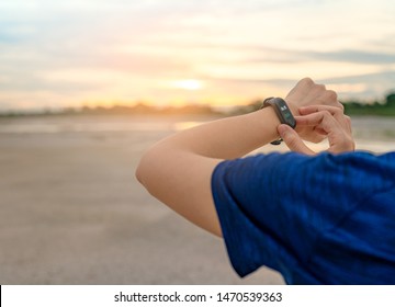 Young Asian woman touching smart band after running in the morning. Wearable computer. Heart rate monitor bracelet. Fitness device. Activity or fitness tracker. Smart watch connected device. Wristband - Shutterstock ID 1470539363