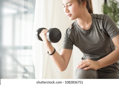 Young Asian Woman Training With Dumbell At Home. Fitness And Healthy Lifestyle Concept