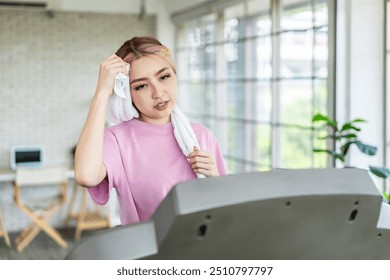 Young asian woman training on elliptical machine. Health care concept, smart training, exercise, home workout - Powered by Shutterstock