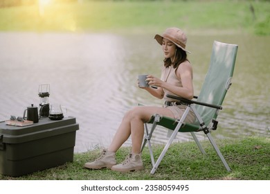 Young Asian woman traveler sitting with camp tent at natural park, Activity and lifestyle on holiday, eco-friendly adventures, Happy woman forest or park while camping concept. - Powered by Shutterstock