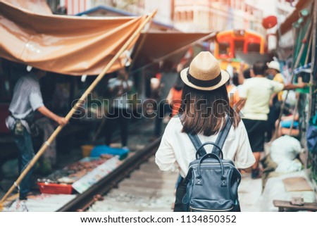 Young asian woman traveler visiting in Maeklong railway market is the most famous traditional traditional market unseen in Thailand at Maeklong district in Samut Songkhram near Bangkok Thailand