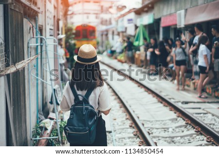 Young asian woman traveler visiting in Maeklong railway market is the most famous traditional traditional market unseen in Thailand at Maeklong district in Samut Songkhram near Bangkok Thailand