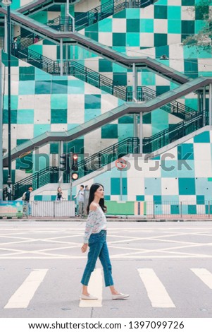 Young asian woman traveler walking cross through the road in the Fortress hill, Hong Kong, China