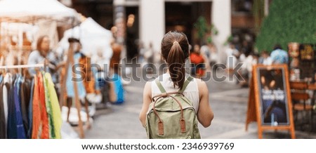 Young asian woman traveler in Yellow dress with bag traveling to NIMMAN on Nimmanhaemin Road, Tourist visit at the Night market city in Chang Mai, Thailand. Asia Travel, Vacation and summer holiday