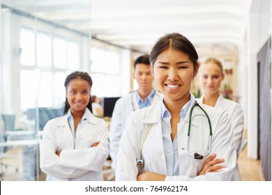 Young Asian Woman As Trustworthy Doctor With Hospital Staff Team 