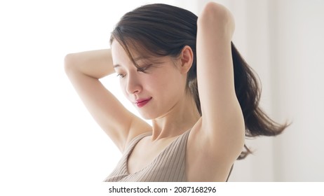 Young asian woman tying her hair. Hair care. Beauty concept.