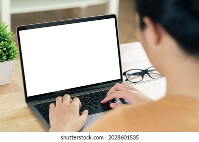 Young Asian Woman typing laptop computer keyboard with white blank screen on the table. working at home, relaxing, online shopping, communication and technology concept