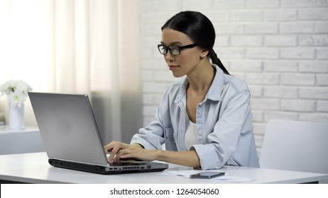 Young Asian Woman Typing On Laptop, Writing Flirty Message On Dating Website