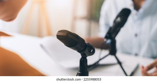 Young Asian woman use microphones wear headphones with laptop record podcast interview for radio. Content creator concept. - Powered by Shutterstock