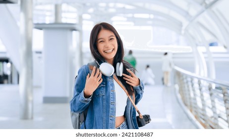 Young asian woman using headphone for listening nice music and walking in city. Girl happiness, smile face. Female love listen music that make her relax and enjoying life - Powered by Shutterstock