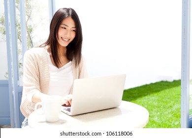 A Young Asian Woman Using Laptop Compute In Cafe