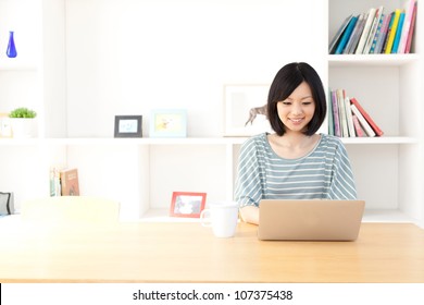 A Young Asian Woman Using Laptop In The Dining Room