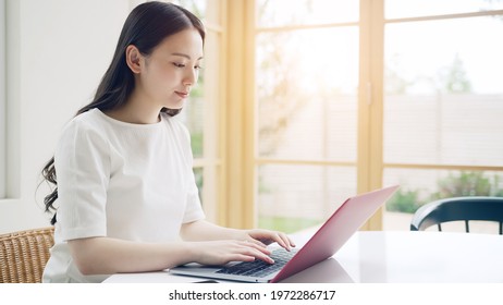 Young Asian Woman Using A Laptop PC In The Room.