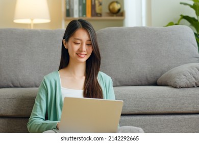 Young Asian Woman Using Laptop Computer For Online Working, Studying, Learning Chatting In Social Media At Home.