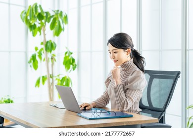 Young Asian Woman Using A Laptop PC In Modern Office.