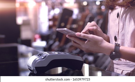 Young Asian Woman Using Mobile Phone - Smartwatch To Purchase Product At The Point Of Sale Terminal In A Retail Store With Near Field Communication Nfc  Radio Frequency Identification Payment