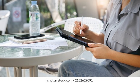 Young Asian Woman Using Personal Tablet For Freelance Job And Working Part Time, Online Education, Training, Blogging Or Online Shopping, Person Working With Online Technology In Modern World Concept.