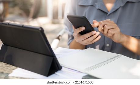 Young Asian Woman Using Personal Mobile Phone For Freelance Job And Working Part Time, Online Education Or Online Shopping, Person Working With Online Technology In Modern World Concept.