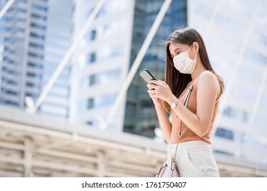 Young Asian woman using smart mobile phone in outside big city at Covid19 outbreak, Infection and Pandemic, commuter and transportation, social distancing and new normal concept - Powered by Shutterstock