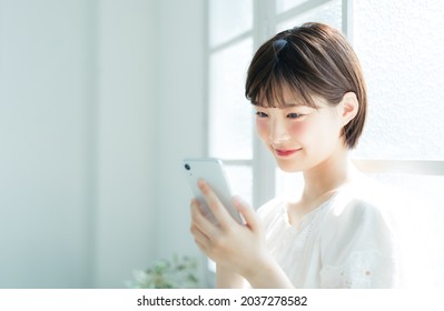 Young Asian Woman Using A Smart Phone. Mobile Communication.