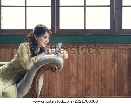 Young asian woman using a smart phone in the room.