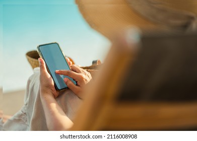 Young Asian woman using smartphone beside the pool at luxury hotel. technology and business concept background. - Powered by Shutterstock