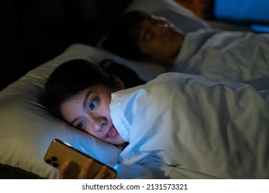 Young Asian woman using smartphone at midnight