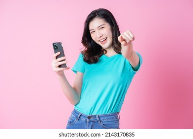 Young Asian Woman Using Smartphone On Pink Background