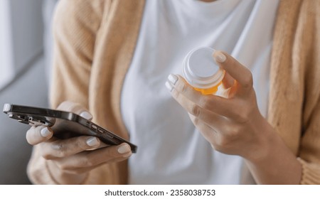 Young asian woman using smartphone Talk with doctor consulting online conference medical app on cellphone girl reading information online on mobile phonewith holding bottled drug. - Powered by Shutterstock